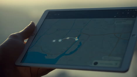 person using a tablet with a map application in an outdoor setting