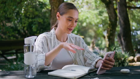 woman freelancer consulting client using smartphone sitting green forest closeup