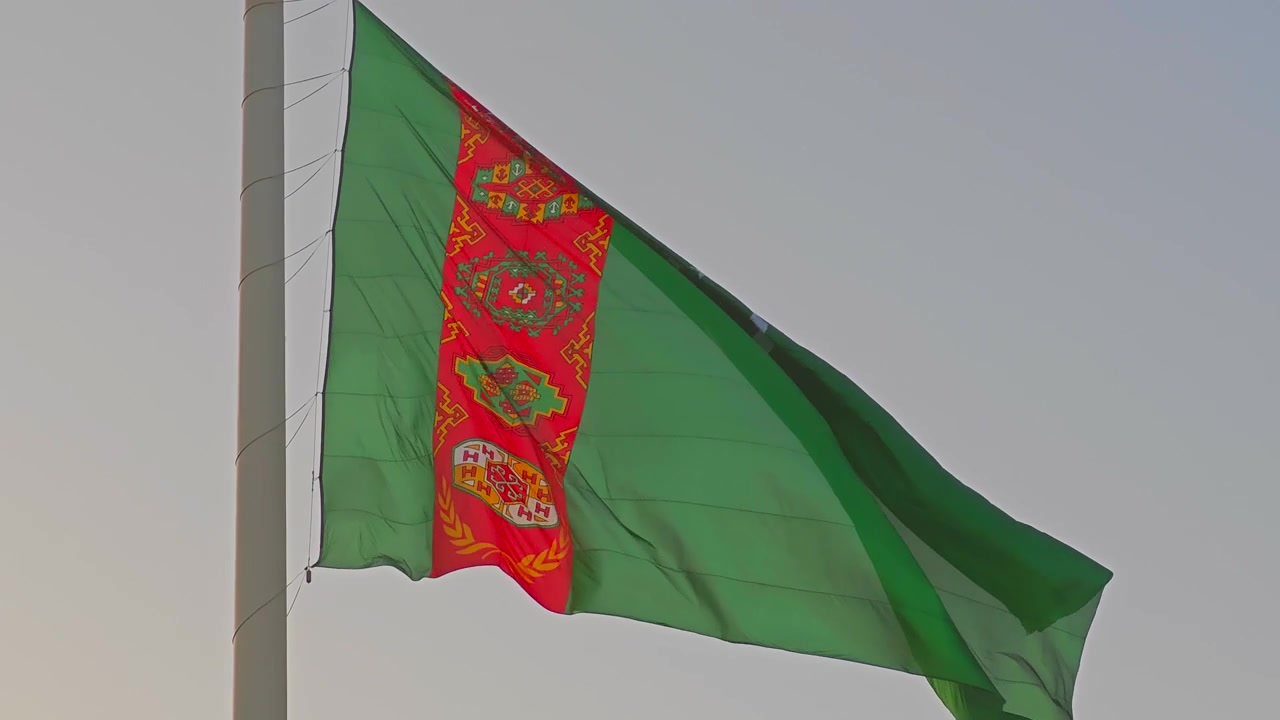 Bandera de Turkmenistán ondeando contra un cielo despejado
