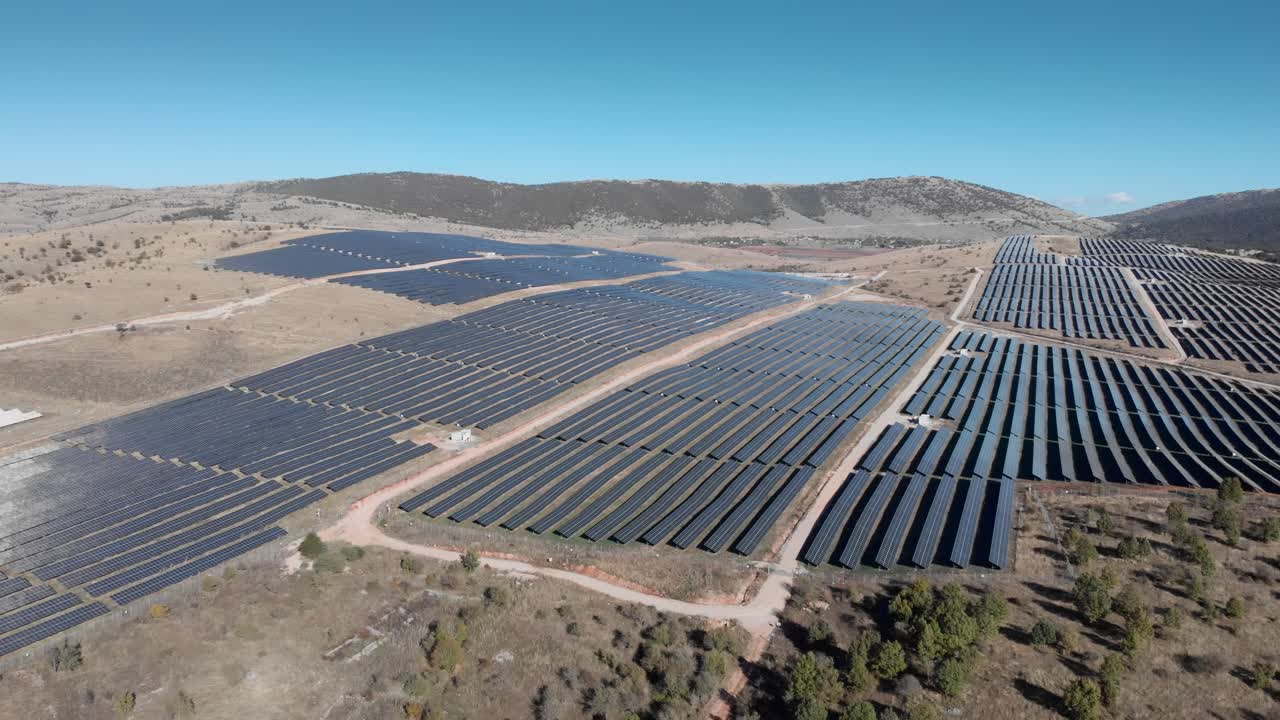 revelando drones sobre mega paneles de parques de energía solar fotovoltaica colinas día soleado