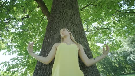 happy beautiful young girl dancing of freedom in summer park with trees in the background.