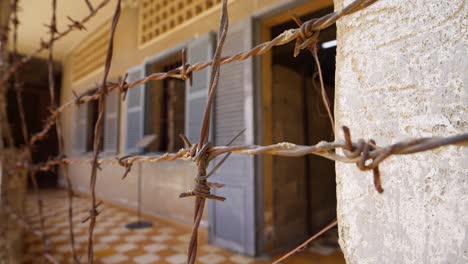 close-up of rusted wire outside torture jail cell block building in phnom penh,