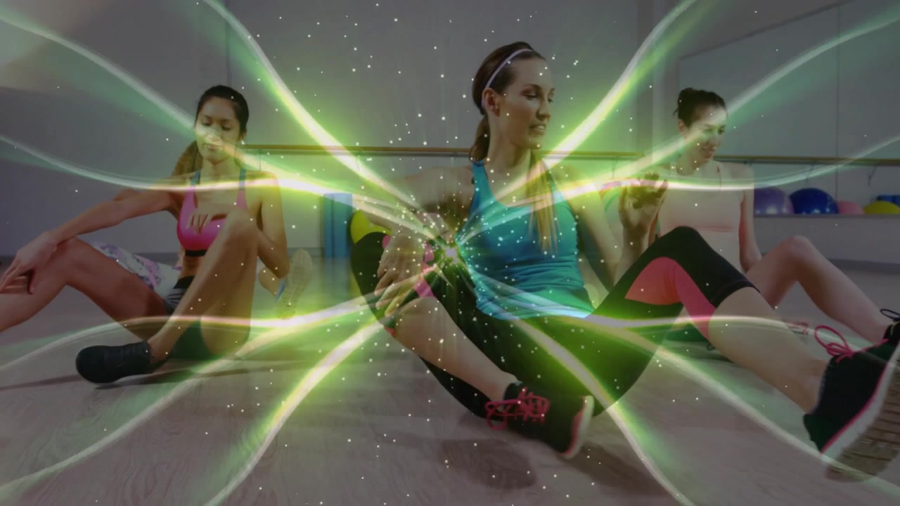 Instrutor de fitness iniciando rotina sentada em tapetes com a turma imitando torções de tronco para mobilidade.