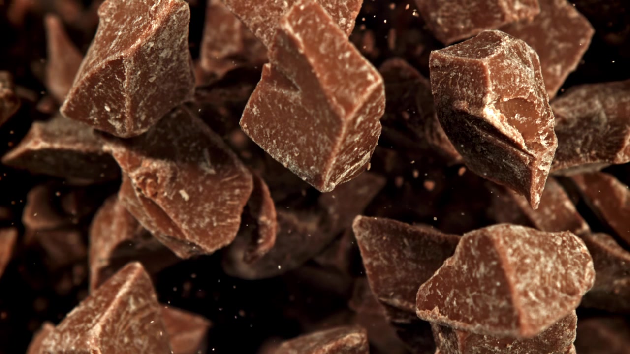 Pezzi di cioccolato che cadono al super rallentatore con messa a fuoco dinamica