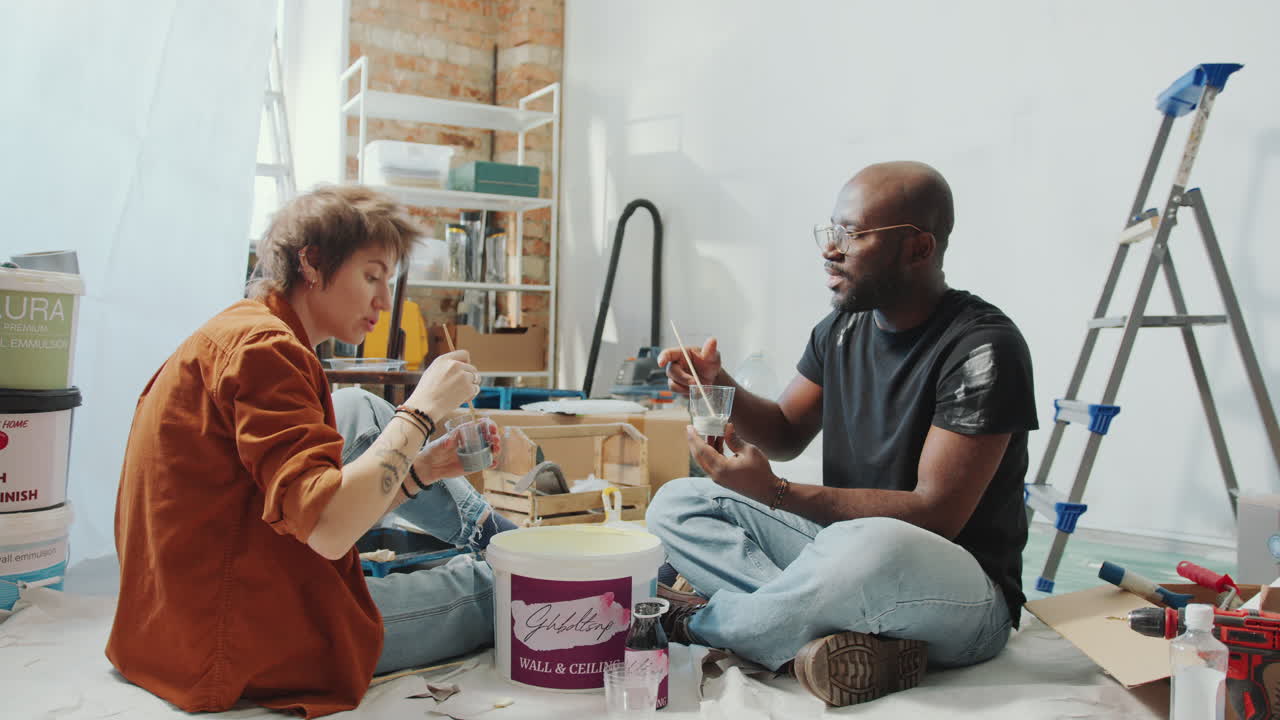 Married Couple Mixing Paint Colors and Talking about Home Renovation