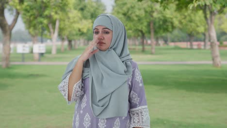 disturbed muslim woman disgusted by bad smell in park