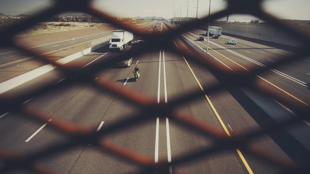 Daytime Traffic on a Multi-Lane Highway with Fence in Foreground