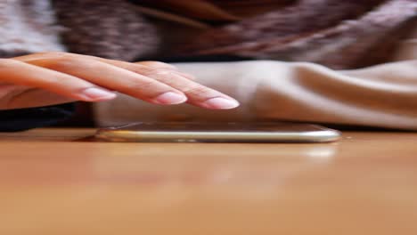 person using smartphone in a cafe