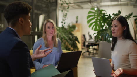 Caucasian-woman-and-Asian-woman-discuss-business-with-biracial-man-in-office