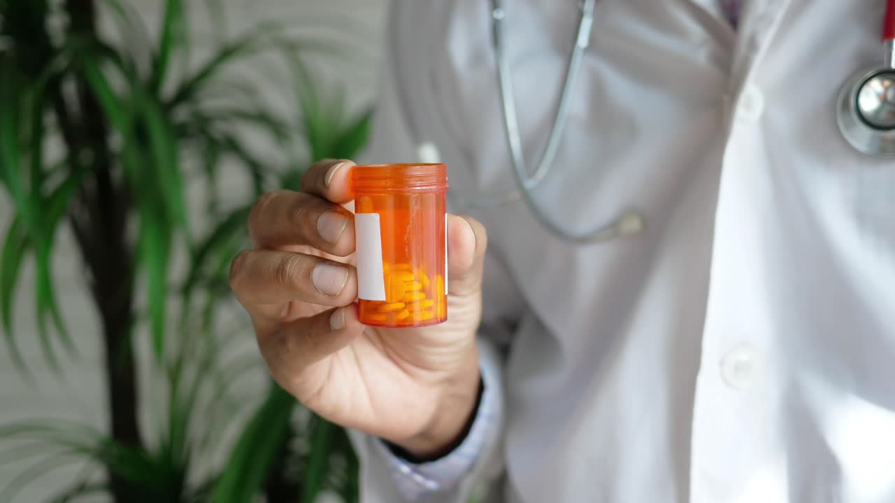 Médico segurando um recipiente de medicamento de prescrição