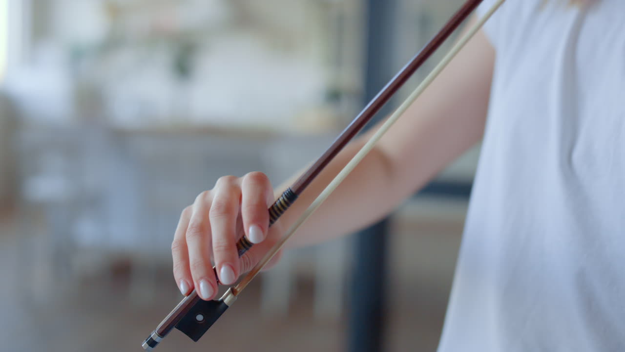 Musician playing violin with bow. Girl creating music on string instrument