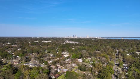 Vista-Aérea-Sobre-Los-Suburbios-De-Murray-Hill,-El-Paisaje-Urbano-De-Jacksonville-En-El-Fondo---Tire-Hacia-Atrás,-Tiro-De-Drones