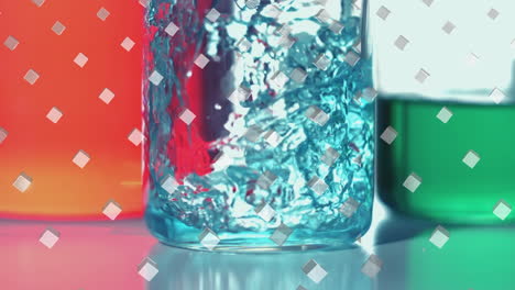 animation of rows of white cubes over blue liquid pouring into laboratory beaker