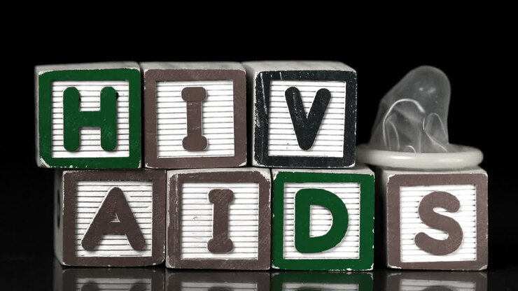 Preservativo che cade su blocchi con le scritte Aids e Hiv