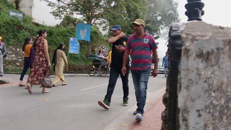 vehicular traffic and people walking by on mall road, mussoorie, uttarakhand, india, slow motion shot.