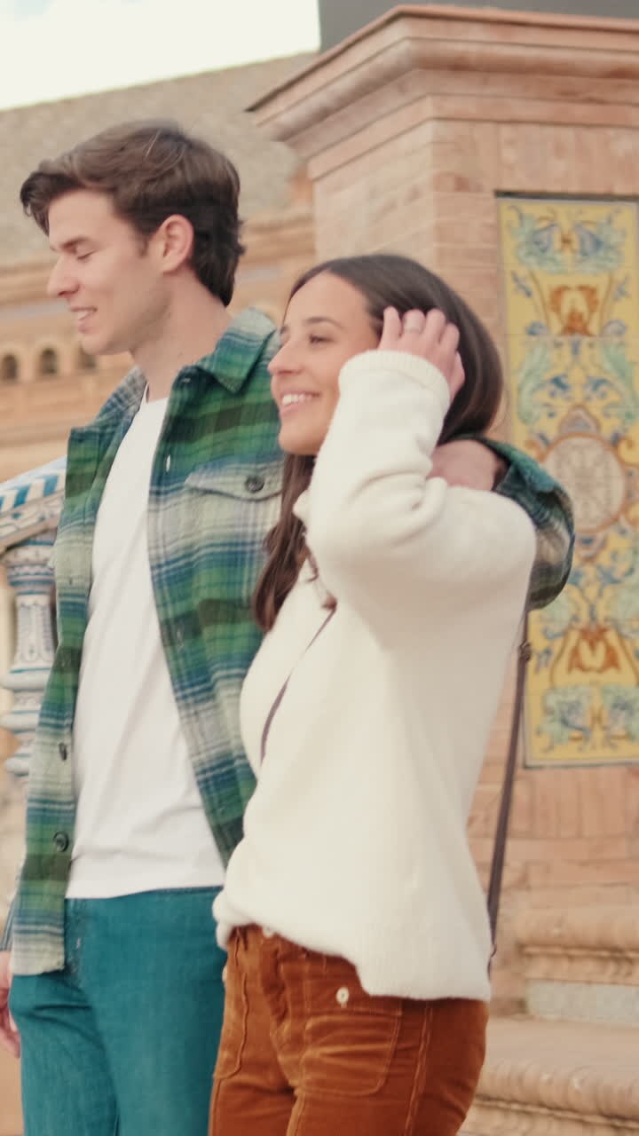 Happy young partners man and woman walking down the stairs of an old European city