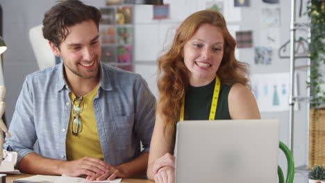 diseñadores de ropa masculinos y femeninos que trabajan en la moda mostrando diseños en videollamada usando computadora portátil