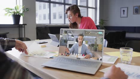 caucasian businessman on laptop video call with caucasian male colleague on screen