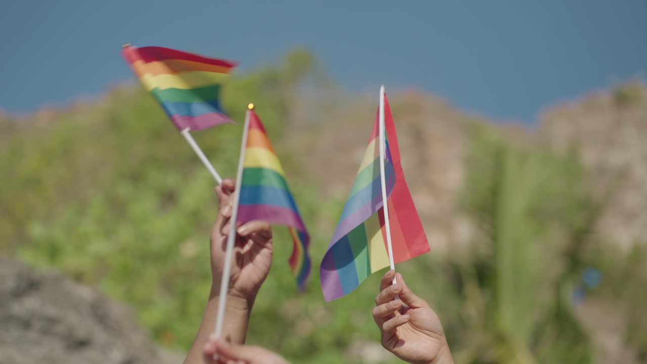 Hands Holding Rainbow Pride Flags