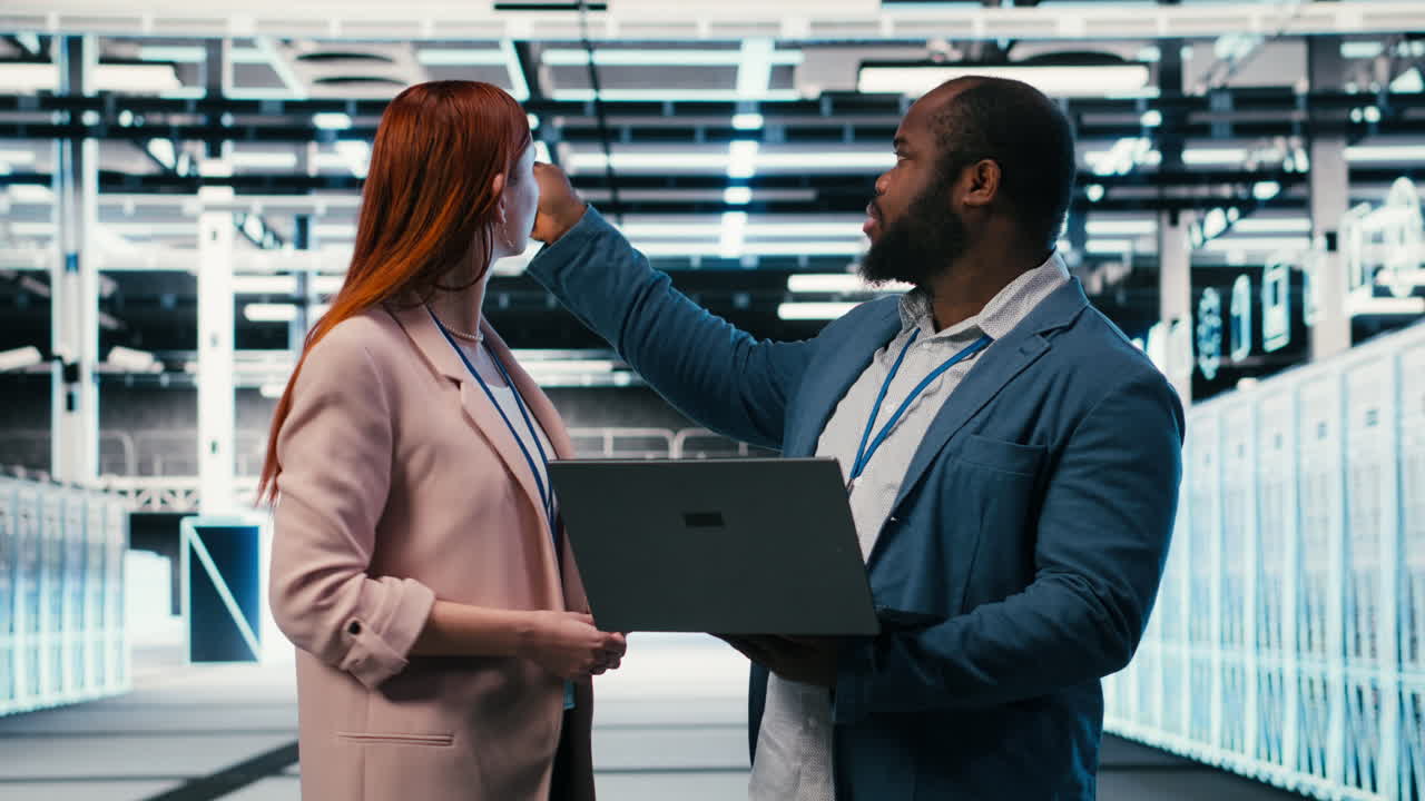 IT Professionals Discussing Data Center Operations on Laptop