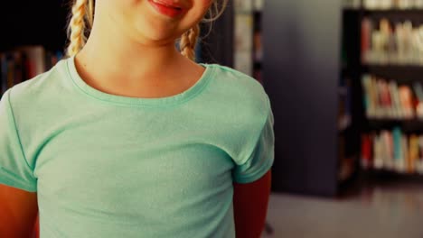 Portrait-of-happy-schoolgirl-standing-in-library-4k