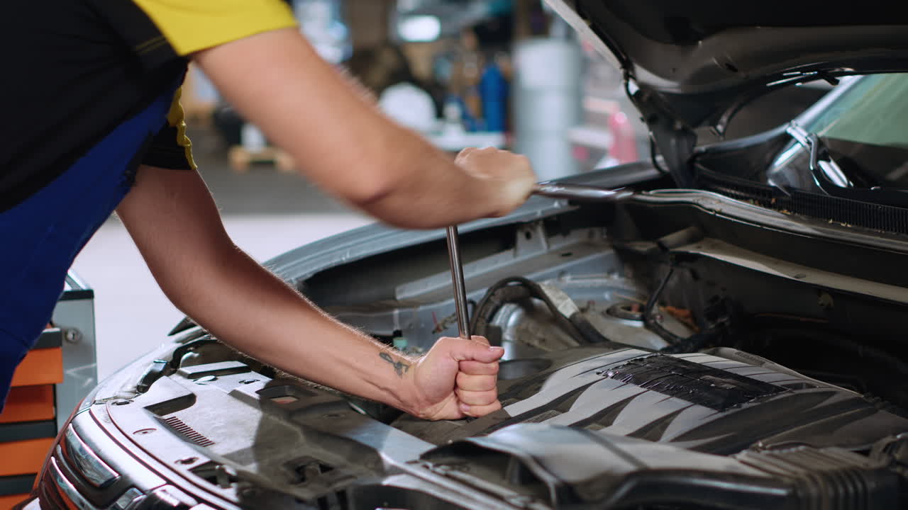 empleado en el servicio de automóviles usa llave inglesa