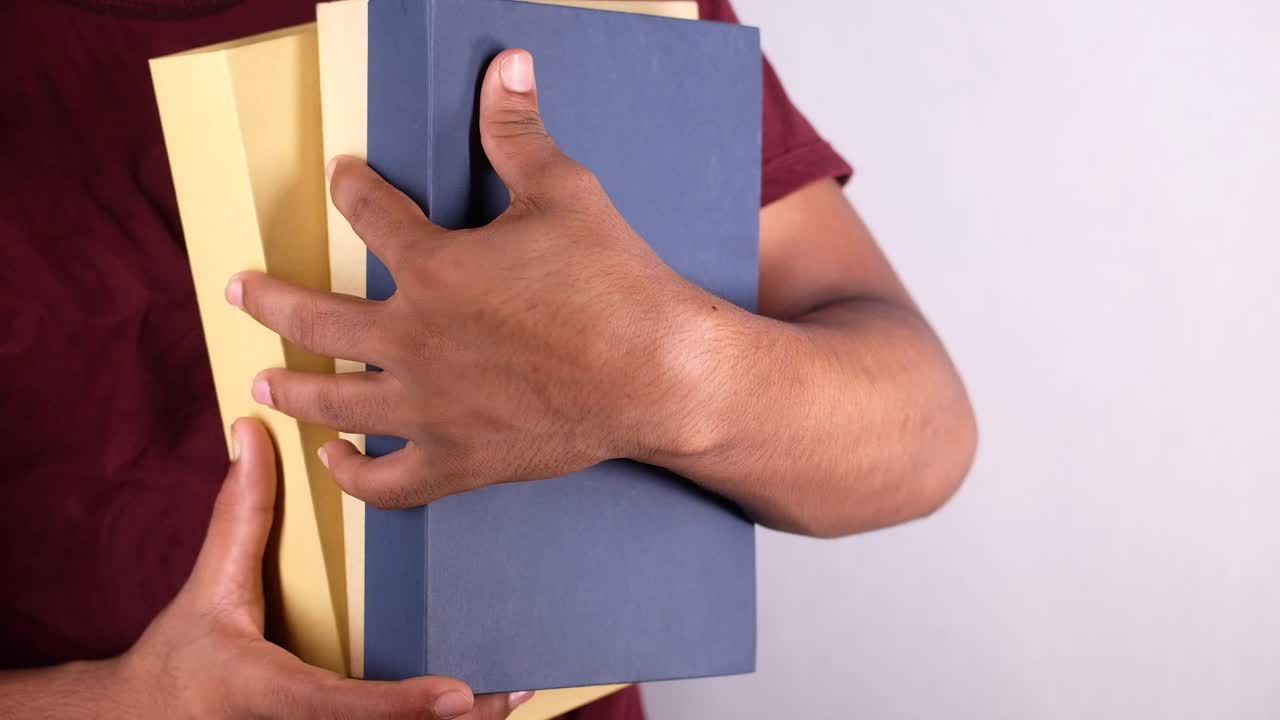 persona que sostiene una pila de libros