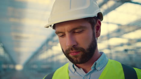 retrato ingeniero de fabricación cara enfocada mirando a la cámara sonriendo satisfecho