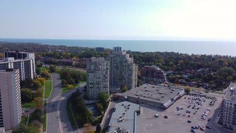 urban neighborhood with apartment buildings, grocery stores, amenities, houses and treed parks near water