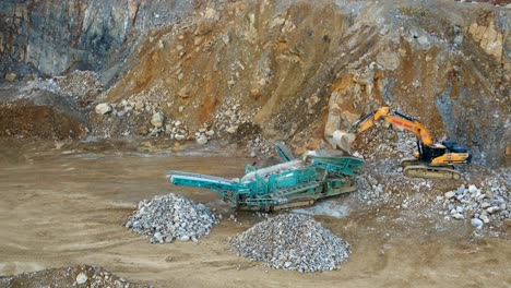 Separating Rock and Gravel: An Aerial Look of an Excavator feeding a Tracked Incline Screener in a Mining Quarry