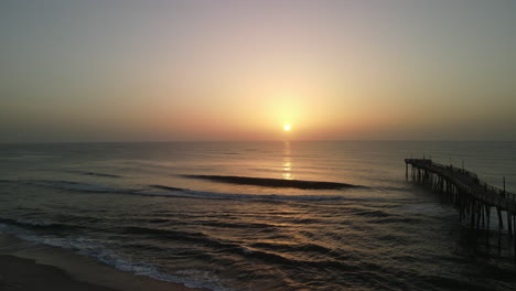amanecer en el océano sobre el muelle de pesca