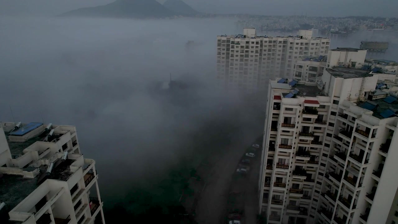 Vista de drone de névoa densa movendo-se através de torres residenciais modernas