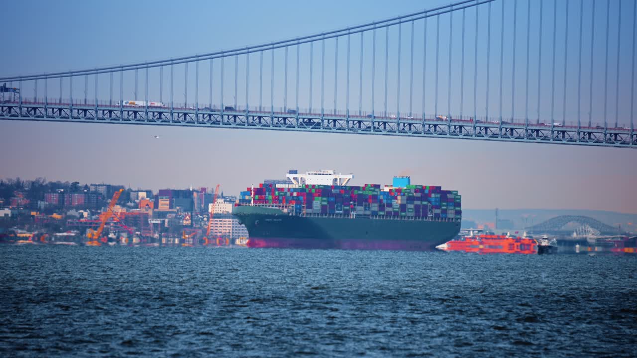 New York, USA, 24 December 2025: Verrazzano Bridge and cargo vessels. Cargo vessels navigate New York Harbor beneath Verrazzano Bridge