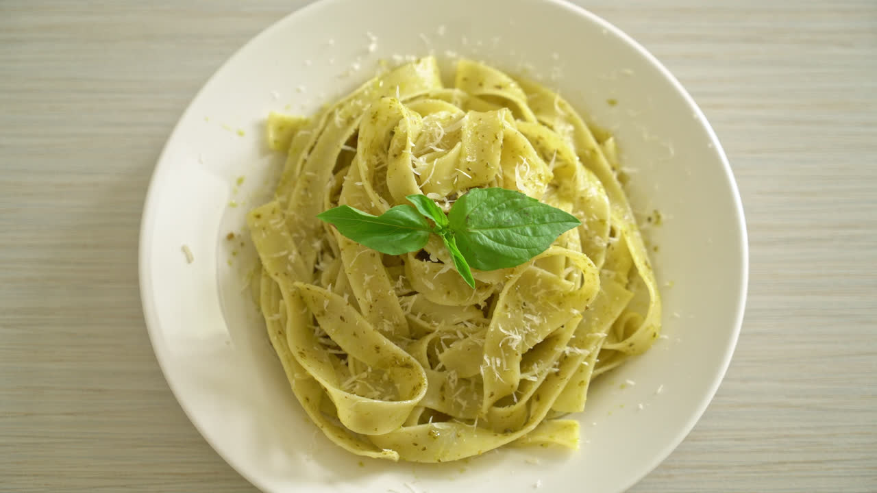 pasta fettuccine al pesto con queso parmesano encima - estilo de comida italiana