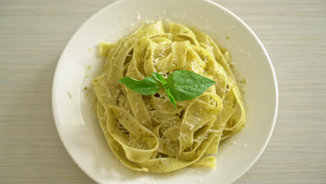 pesto fettuccine pasta with parmesan cheese on top - italian food style