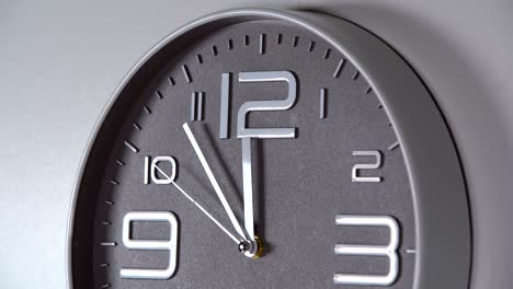 reloj de pared en un fondo gris. 23:55