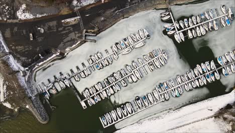 top down shot of lighthouse landing, revealing full frozen marina in winter time