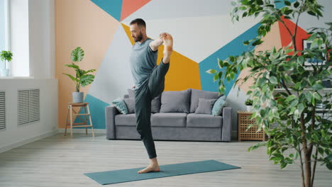 man practicing yoga in living room