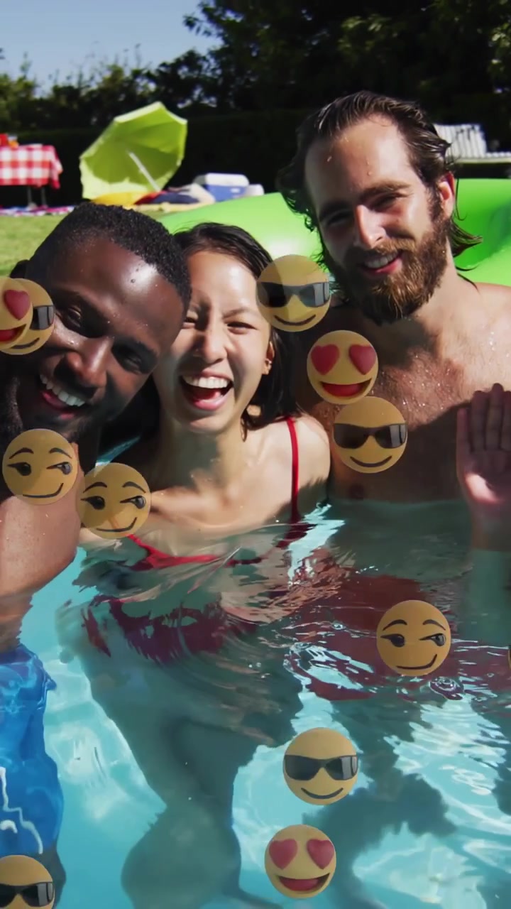 Video verticale: trio che tiene un telefono, posa in piscina, scatenando uno sciame di emoji, ridendo per un'app social