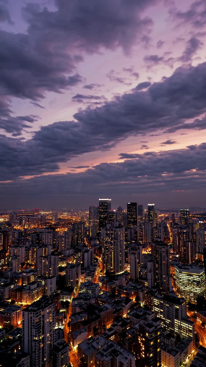 Dramatic aerial view of a cityscape at dusk, with glowing lights under ...