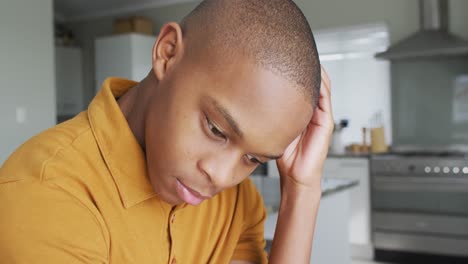 video of sad african american boy sitting on sofa at home