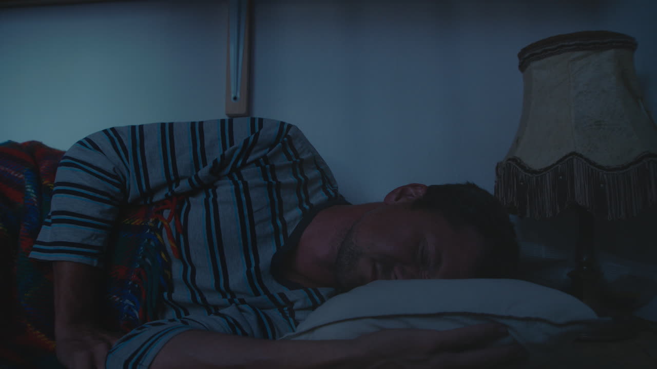 hombre durmiendo en la cama por la noche