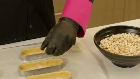 Hands-filling-tartlets-with-loubia.-Close-up,-gimbal