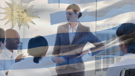 waving uruguay flag against caucasian senior businesswoman giving a presentation at office