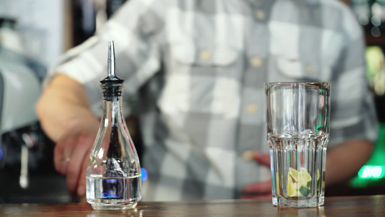 Barman squeezing the fresh lime juice making tasty mojito alcoholic cocktail on the bar counter