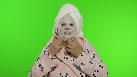 Ältere-Großmutter-Nach-Der-Dusche.-Alte-Frau,-Die-Gesichtsmaske-Aus-Kosmetischem-Stoff-Aufträgt
