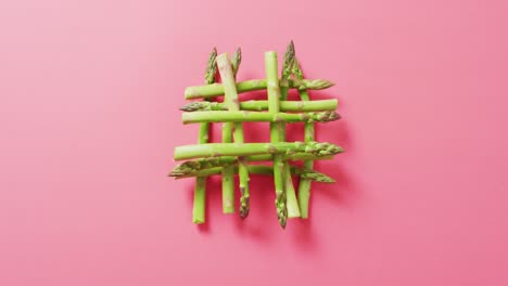 video of fresh asparagus over pink background