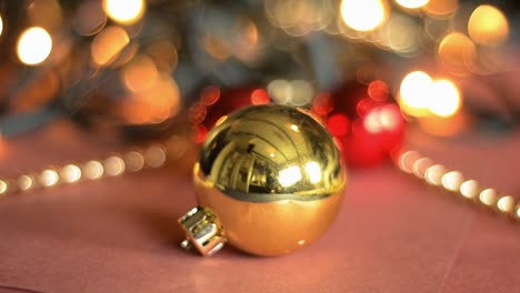 a real time well focused shot of a golden christmas decoration ball with fairylights flickering in the background giving a happy festive feeling