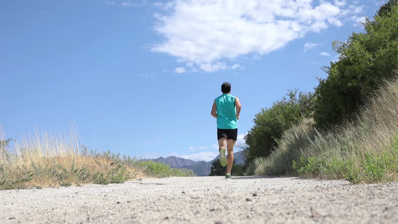 Slow Motion Shot of a active man going trail running on the outdoor mountainous trails of Draper City, Utah