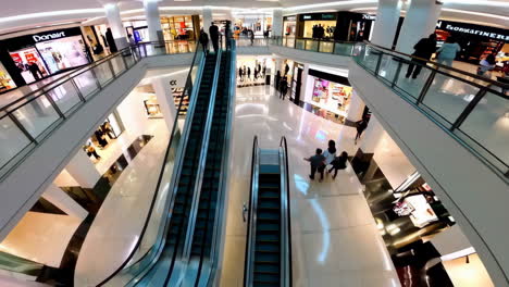 people navigating a bustling, multi-level modern shopping mall